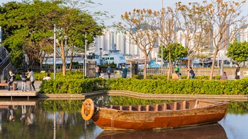 從公園外望，水景區似乎與愛秩序灣相連。當中的舢舨與背後的渡輪形成傳統與現代水上交通工具的對比。